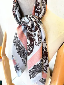 Baroque floral silk scarf with Greek key border displayed on a wooden mannequin