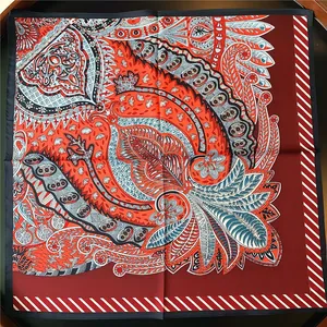 Detailed view of the dark red paisley silk scarf with vibrant orange and blue patterns