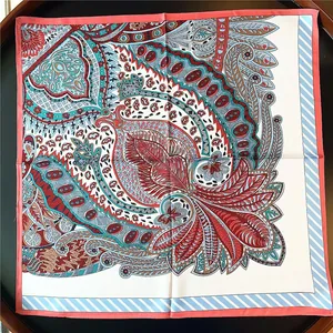 Detail shot of the paisley floral pattern and diagonal stripe border on a satin scarf