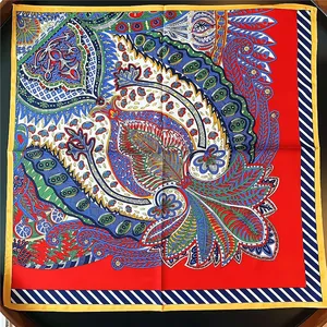 Close-up of 53cm silk scarf with paisley and floral patterns on black reflective surface