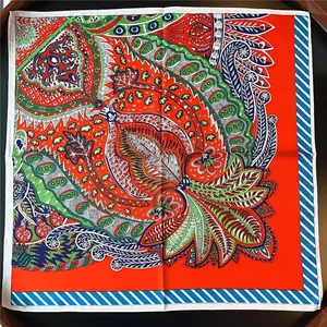 Macro shot of 53cm silk scarf featuring intricate paisley and floral patterns in red