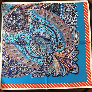 Flat lay of a 53cm silk-textured square scarf featuring blue paisley and floral prints