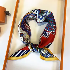Detail of 53cm silk scarf with red paisley print inside a signature orange gift box