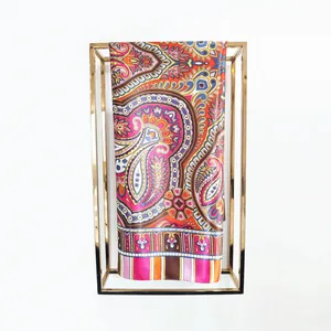 Close-up of bohemian paisley silk scarf with vibrant patterns on gold metal display stand