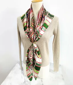 Detail of bohemian paisley silk scarf with gold ring buckle on beige knitwear
