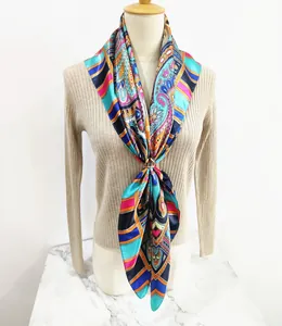 Detail of bohemian paisley silk scarf featuring vivid floral patterns and a gold ring buckle