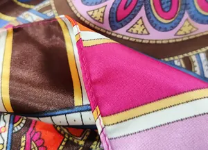 Close-up of bohemian paisley silk scarf showing vivid floral patterns and fine hem detail