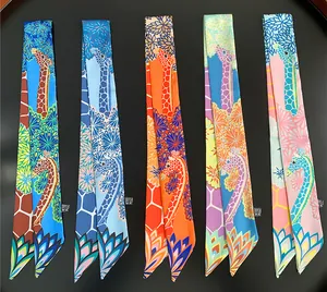 Detailed view of five colorful twilly silk scarves with giraffe and floral patterns