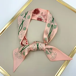 Pink daisy silk ribbon scarf with abstract plant prints tied in a bow on a beige stand