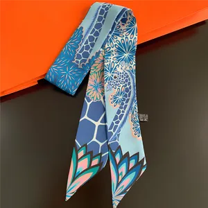 Detailed view of sky blue silk scarf with giraffe prints and vibrant geometric patterns