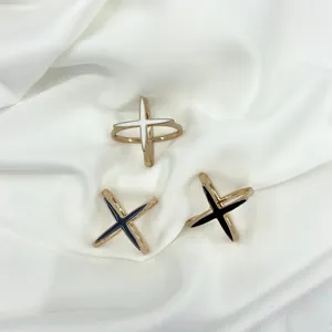 Close-up of X-shaped crystal silk scarf clips with white, black and blue enamel in gold