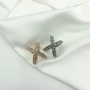 Detail shot of X-shaped scarves clips with inlaid crystals in gold and silver finish