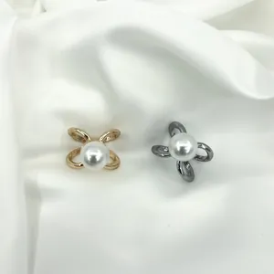 Close-up of pearl scarf clips in gold and gunmetal finish on white silk background