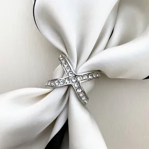 Elegant X-shaped silver scarf buckle with sparkling crystals on white silk scarf