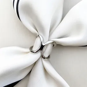 Polished silver V-shape scarf buckle with three-ring design on white silk neckerchief