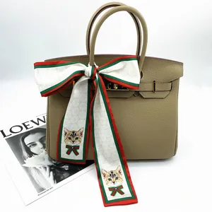 Taupe leather tote bag with elegant cartoon cat silk ribbon wrapped on the top handle