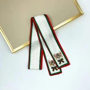 Elegant ivory cat print ribbon with red-green stripes and gold geometric pattern