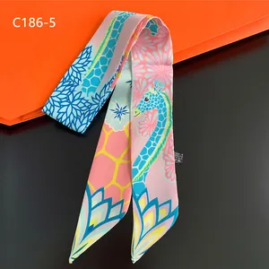 Detail showing giraffe print silk scarf texture and 100% polyester wash label on black surface