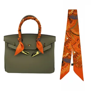 Sac à main en cuir taupe classique avec ferrures dorées et ruban de soie orange imprimé
