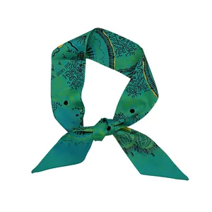 Détail d'un foulard en soie vert émeraude avec motifs abstraits et texture satinée