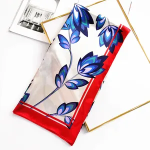 Detailed macro view of floral silk scarf with red edges and elegant blue patterns