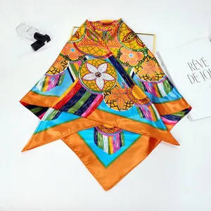 Detailed texture of bohemian floral silk scarf with vibrant orange border and geometric print