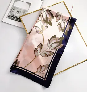 Detail of silk-feel scarf with maple leaf print next to a minimalist fashion magazine