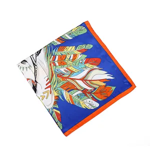 Gros plan détaillé d'un foulard en soie bleu avec un motif de plumes colorées