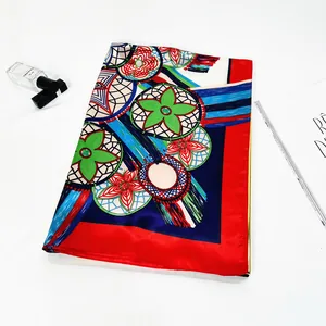 Detailed view of folded silk scarf with vibrant floral patterns and silky finish texture