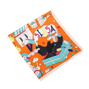Close-up of vibrant orange silk scarf featuring cartoon birds and pop art illustrations