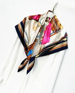 Detail of silk satin scarf with luxury chain and handbag prints on clothing hanger