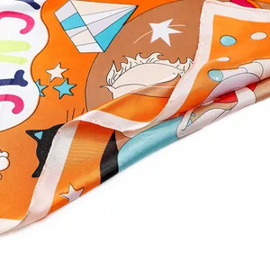 Macro detail of silk texture orange scarf with cute cartoon cat prints and stars