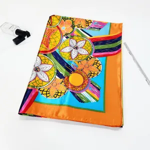 Detailed texture of satin silk scarf with bohemian patterns and vibrant orange borders