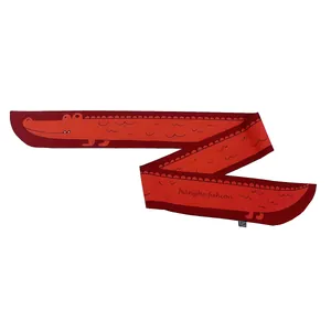 Détail d'un foulard en soie rouge avec imprimé crocodile et finitions soignées