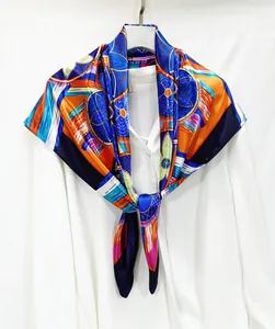 Macro detail of royal blue and orange silk scarf featuring geometric floral patterns