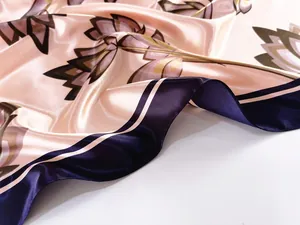 Close-up of floral print satin scarf with elegant blue border and glossy texture detail