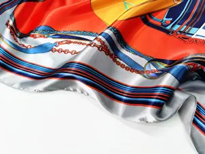 Macro detail of silk scarf showing smooth texture with orange and blue horse belt patterns