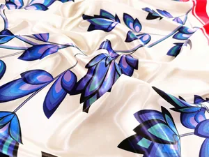 Detailed close-up showing satin silk scarf texture with blue and purple leaf patterns