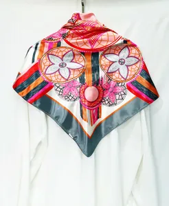Detailed pattern of bohemian silk scarf with floral and geometric motifs on white shirt