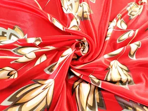 Close-up of silky red square scarf with autumn leaf patterns showing satin texture