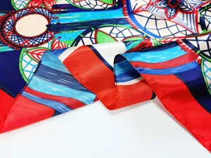 Close-up of silky floral scarf showing multi-color dreamcatcher patterns and red hem