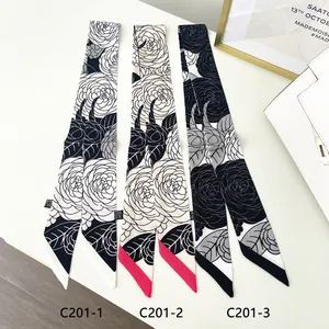 Close-up of three narrow camellia floral ribbons for handbags in black, white and red colors