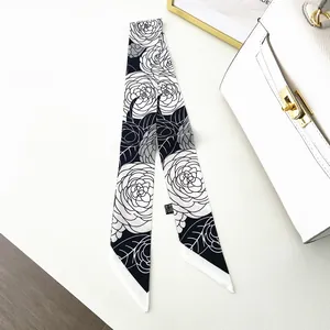 Detail of black and white camellia pattern skinny scarf wrapped on luxury bag handle