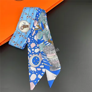 Detailed view of blue floral polyester twilly scarf with owl and palm tree patterns