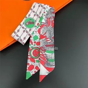 Detailed macro view of floral print twilly silk scarf showing 100% polyester fabric label