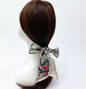 Detailed view of floral silk hair ribbon with Paris print tied in a bow on a hairstyle