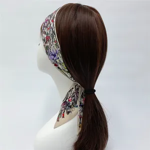 Detail of floral silk scarf tied as a hair ribbon on a ponytail with lily pattern