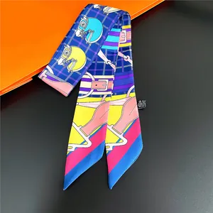 Deep blue horse print twilly scarf with equestrian motifs on an orange gift box
