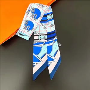 Detailed close-up of silk twilly scarf featuring horse head patterns and equestrian buckles