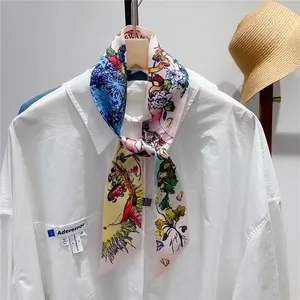 Detailed styling of a pink floral silk scarf tied elegantly on a white shirt collar